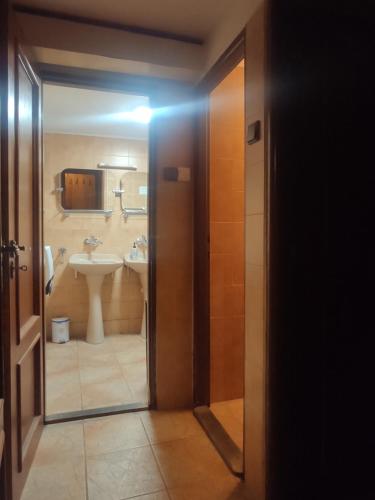 an open door to a bathroom with a sink and a toilet at Chata Chabadová in Lysica