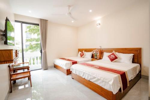 a hotel room with two beds and a window at Hotel Hải Âu in Sầm Sơn