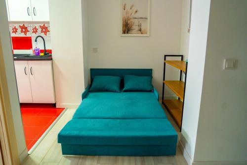 a blue bed in a room with a kitchen at Studio Vata in Vaţa de Jos