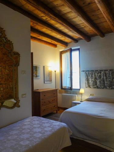 a bedroom with two beds and a window at Ai Tigli in Castel dʼArio