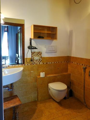 a bathroom with a toilet and a sink at Ai Tigli in Castel dʼArio