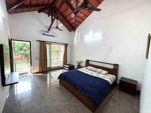 a bedroom with a bed and a large window at Rego Farms in Mangalore