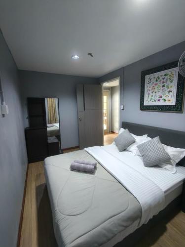 a large white bed in a bedroom with blue walls at Kundasang height valley in Ranau