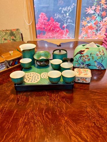 a tray with a group of bowls and cups on a table at 楓の宿1号館 in Osaka