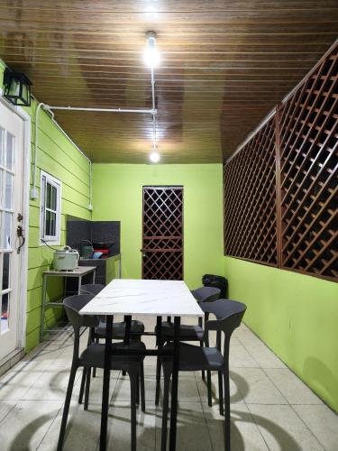 a table and chairs in a room with green walls at Kundasang height valley in Ranau