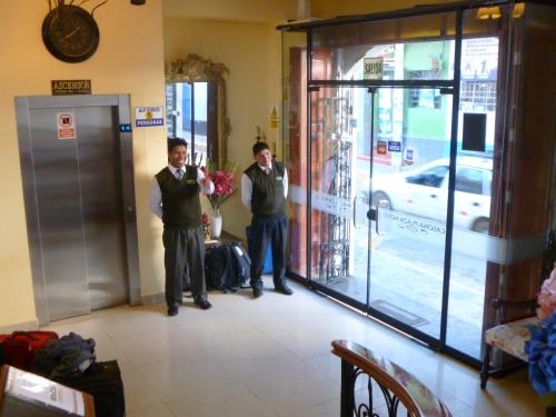 two men standing in front of a door at Casona Plaza Hotel Centro in Puno
