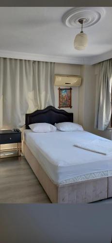 a bedroom with a large bed with white sheets at Huzur Otel Ümraniye in Istanbul