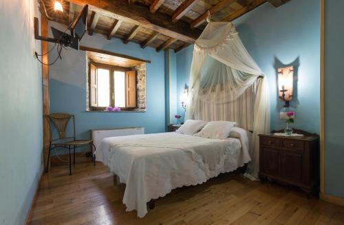 a bedroom with a white bed and a window at O Muiño de Pena in O Pino 