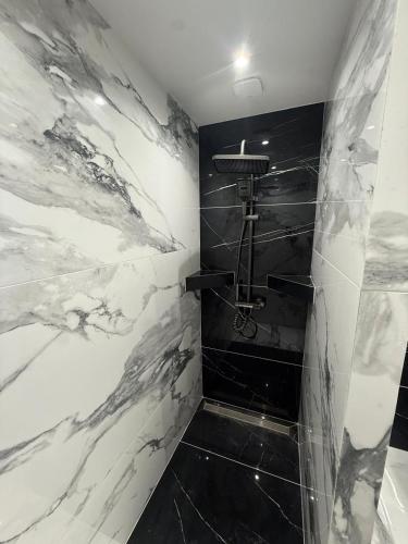 a bathroom with black and white marble walls and a shower at Melrose Loft with master suite in Sanary-sur-Mer