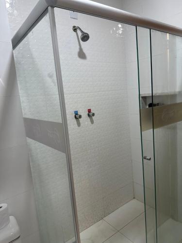 a shower with a glass door in a bathroom at Hotel Oscar Gold Janaúba in Janaúba