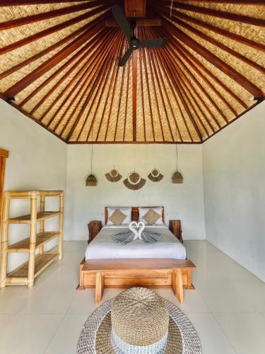 a bedroom with a bed and a wooden ceiling at Hillside bali in Kubupenlokan