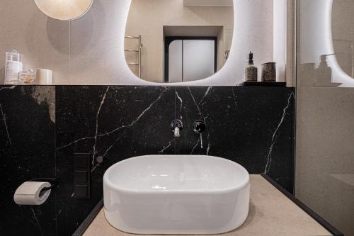 a bathroom with a white sink and a mirror at SPA apartamentai Palanga in Palanga