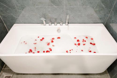 a white bath tub filled with red rose petals at Hotel Hải Âu in Sầm Sơn