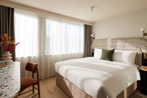 a bedroom with a large white bed and a window at Hotel Indigo London K West Shepherd's Bush by IHG in London