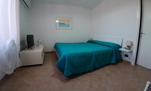 a bedroom with a blue bed and a television at Riserva Verde in Castel Porziano
