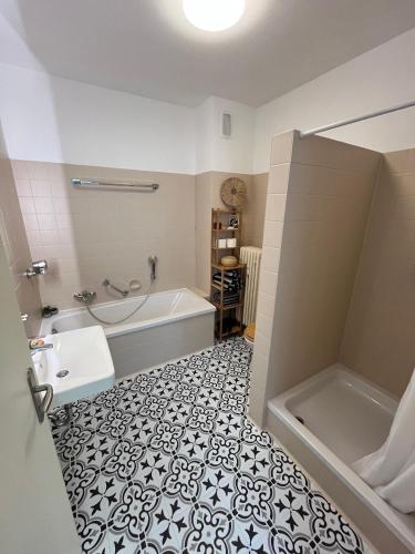 a bathroom with a tub and a sink at Idyllische Wohnung mit Bergblick nah am Simssee in Stephanskirchen