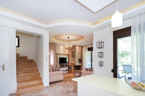 a living room with white walls and a staircase at Sandra Villa Nea Skioni several steps from the sea in Nea Skioni