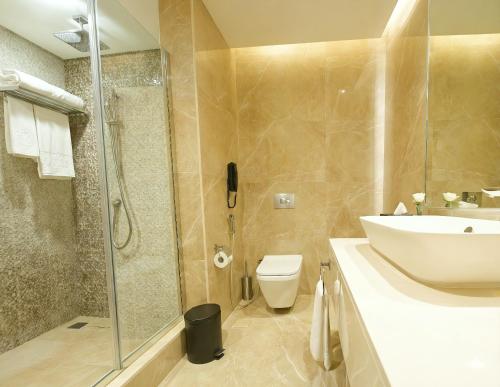 a bathroom with a sink and a toilet and a shower at Edge Riyadh Al Rabie in Riyadh