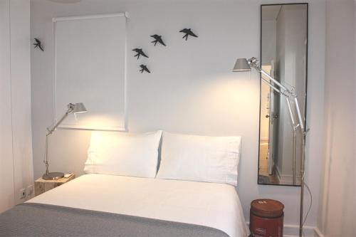 a bedroom with a bed with three birds on the wall at Baixa Charming Apt. | Cascão 18 in Lisbon