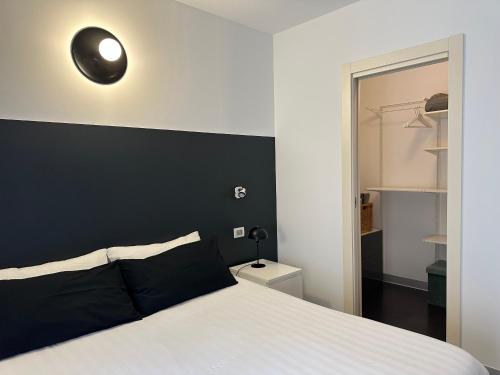 a bedroom with a white bed with a black wall at Civico6 in Tirano