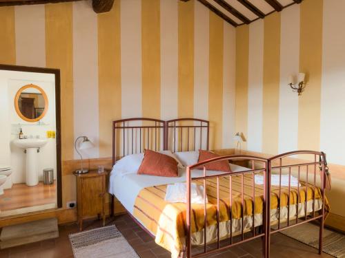 a bedroom with a bed and a mirror and a sink at Tuscan Farmhouses at Castello del Calcione Estate in Lucignano