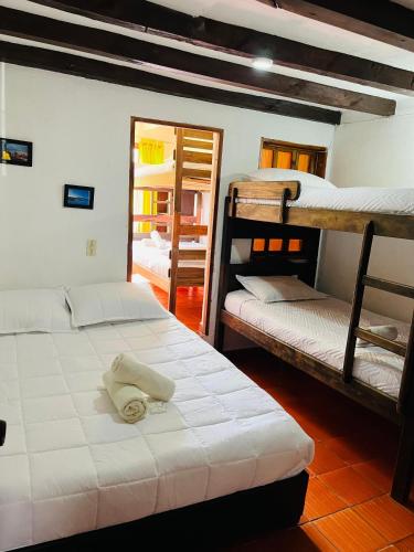 a room with three bunk beds and a mirror at Hospedería Villa Lucía in Villa de Leyva