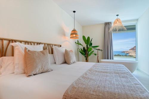 a bedroom with a bed with a view of the ocean at Amadores View - Adults only in Mogán