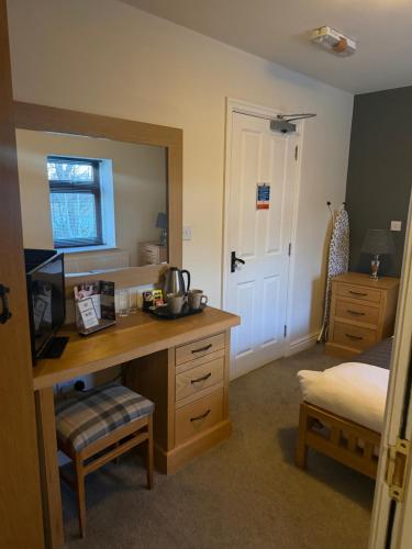 a bedroom with a desk and a bed and a mirror at Charnock Farm in Leyland