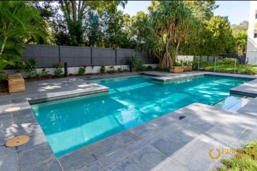 a swimming pool with blue water in a backyard at Sapphire Heaven in Woorim