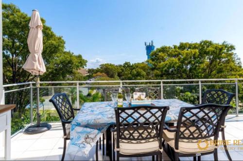 a table and chairs on a balcony with an umbrella at Sapphire Heaven in Woorim