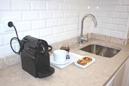 a kitchen counter with a coffee maker next to a sink at Baixa Charming Apt. | Cascão 18 in Lisbon