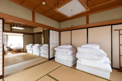 a room with several stacks of mattresses in a room at Arai アライ in Takayama