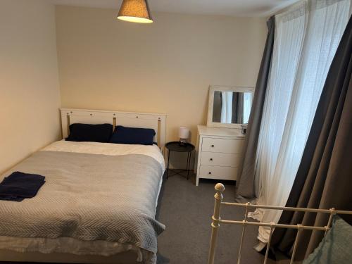 a bedroom with a bed and a dresser and a mirror at Rose villa in Bristol