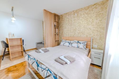 a bedroom with a bed with towels on it at Studio H&M in Užice