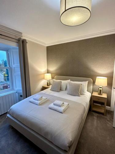 a bedroom with a bed with two towels on it at BROOMBANK, Melrose in Gattonside