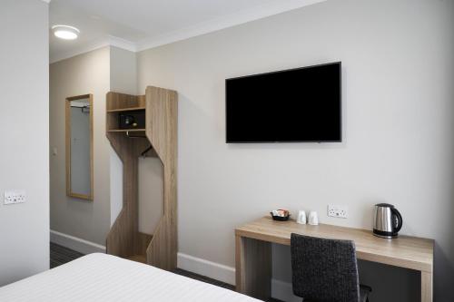 a bedroom with a desk and a tv on a wall at Four Points Flex by Sheraton Edinburgh in Edinburgh