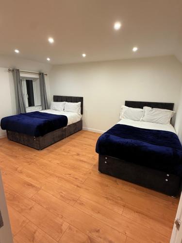 two beds in a room with wooden floors at Pear Barn Haven in Wisbech Saint Mary