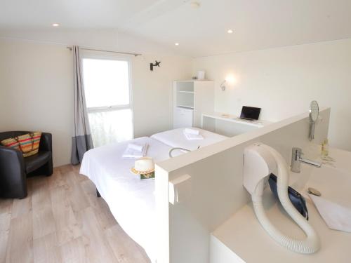 a white room with a bed and a window at ULVF Les Beaupins in Saint-Denis-dʼOléron