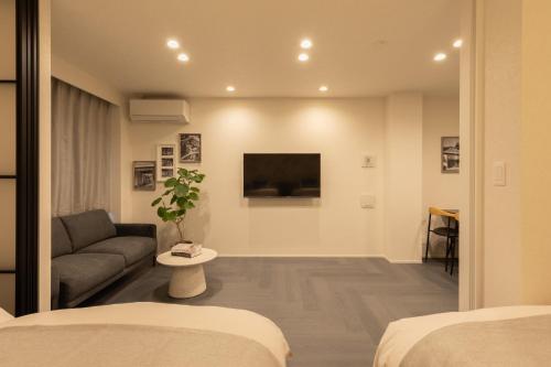a living room with a couch and a tv at Hotel Kototoi East in Tokyo