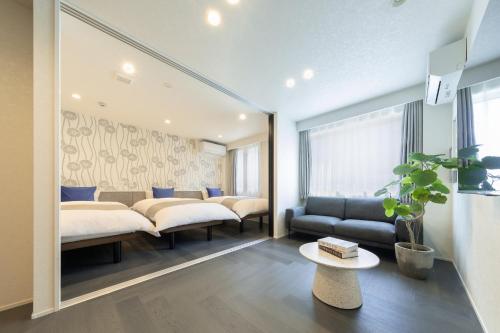 a hotel room with two beds and a couch at Hotel Kototoi East in Tokyo