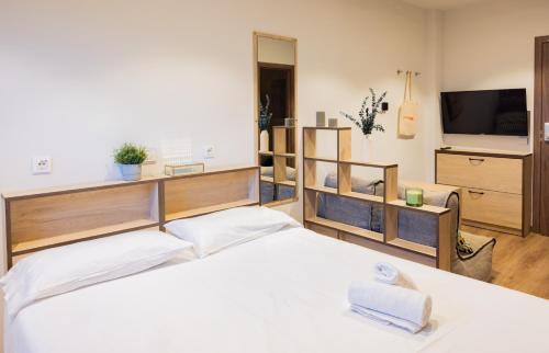 a bedroom with a white bed and a television at Stephouse Pozuelo Europa in Madrid