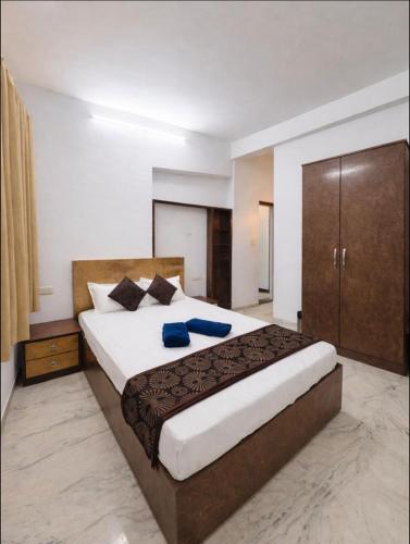 a bedroom with a large bed with blue pillows at Shalimar Villa-2 in Jāmb