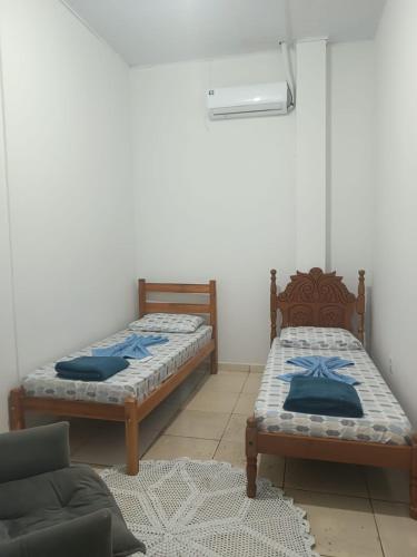 a room with two beds and a couch at Casa perto da Unemat in Cáceres