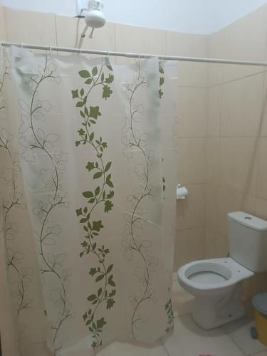 a bathroom with a shower curtain with a toilet at Casa perto da Unemat in Cáceres