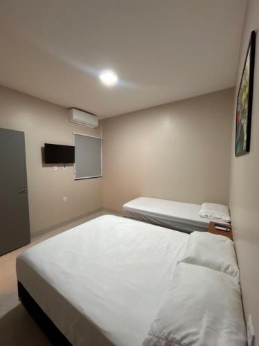a bedroom with two beds and a tv at LD Smart Residence in Castanhal