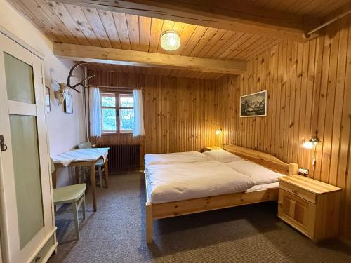 a bedroom with a bed in a wooden room at Chalupa Jaseň in Ždiar