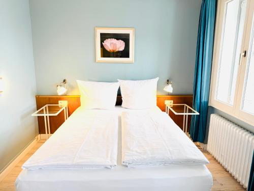 a white bed in a room with a window at Hotel Pelli Hof Rendsburg by Tulip Inn in Rendsburg