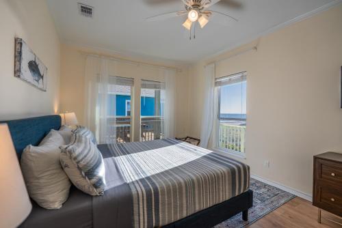 a bedroom with a bed and two windows at Ocean View l Pet Friendly in Gilchrist