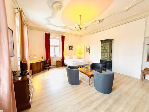 a living room with a table and chairs and a fireplace at Hotel Pelli Hof Rendsburg by Tulip Inn in Rendsburg