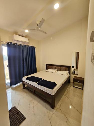 a bedroom with a bed and a blue curtain at Zen Villa in Murūd